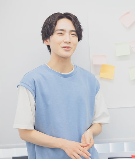 ホワイトボードの前で話す男子学生