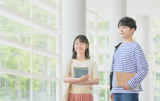 資料を持って話す女子学生たち